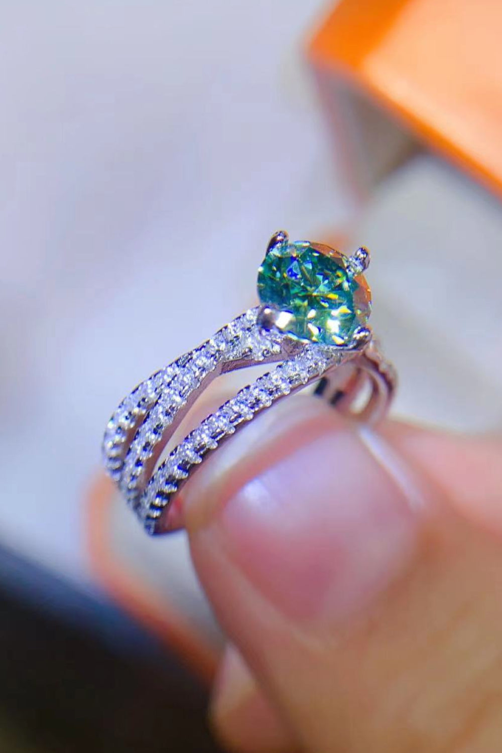 Twisted pavé halo ring with light green stone and sterling silver band.