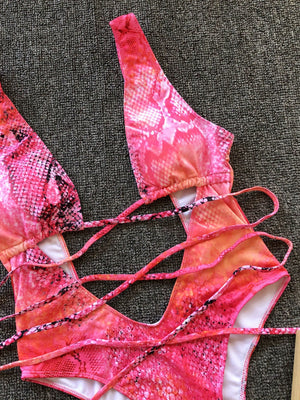 Snakeskin plunge swimsuit with crisscross straps in hot pink and orange gradient.