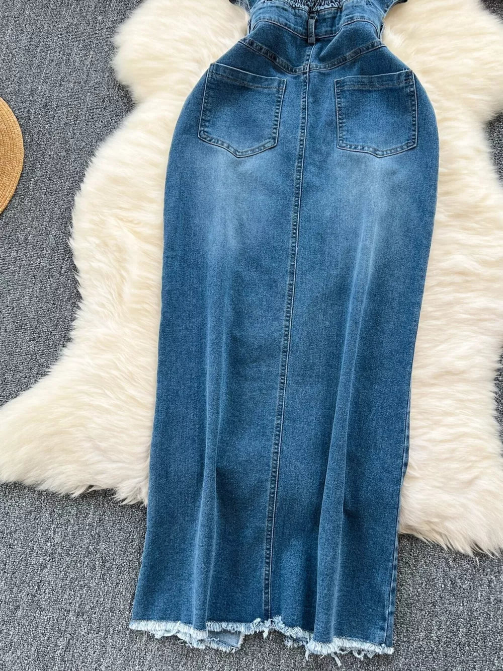 Denim maxi dress with frayed hem, back pockets, and button front detail.