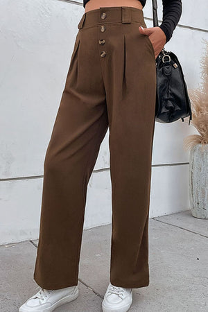 Brown high-waisted tailored wide-leg trousers with button detail and pleats.