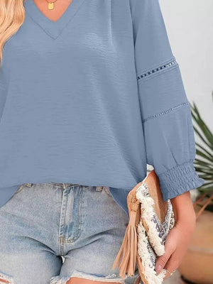 Light blue polyester blouse with smocked cuffs and decorative sleeve details.