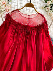 Red sheer blouse with rhinestone embellishments and feather trim neckline.