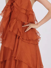 Orange halter maxi dress with cascading ruffles and a sheer overlay.