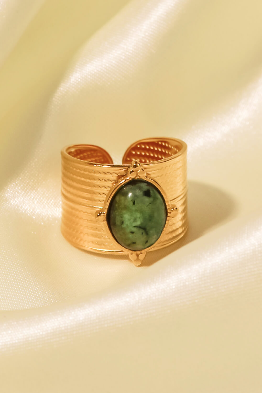 Textured cuff ring with green stone detail on gold band
