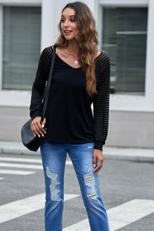 Black sheer stripe raglan sleeve top with V-neck, styled with ripped jeans.