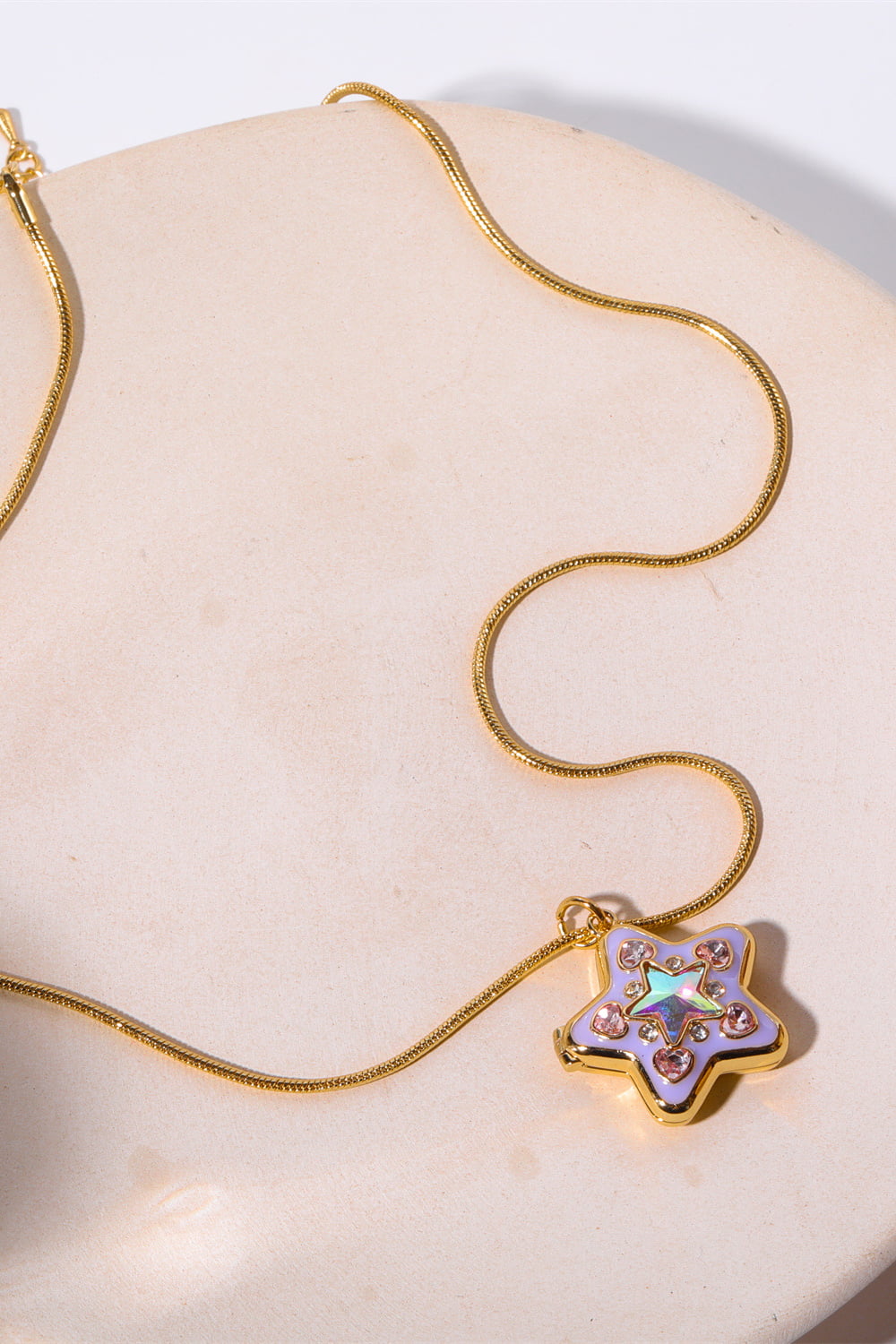 Locket Starburst Pendant Necklace in lavender with crystal accents and gold chain.