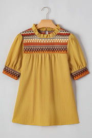 Mustard blouse with embroidered yoke, ruffled neckline, and puff sleeves.