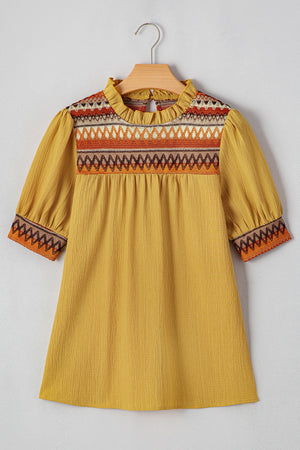 Mustard blouse with embroidered yoke, ruffled neckline, and puff sleeves.