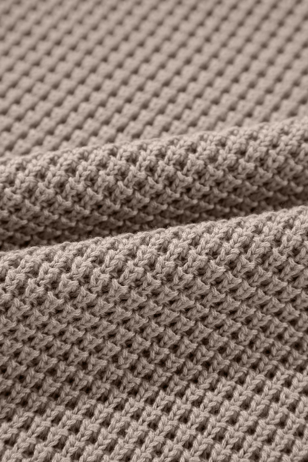 Mocha knit turtleneck sweater with checkerboard and stripe sleeves.