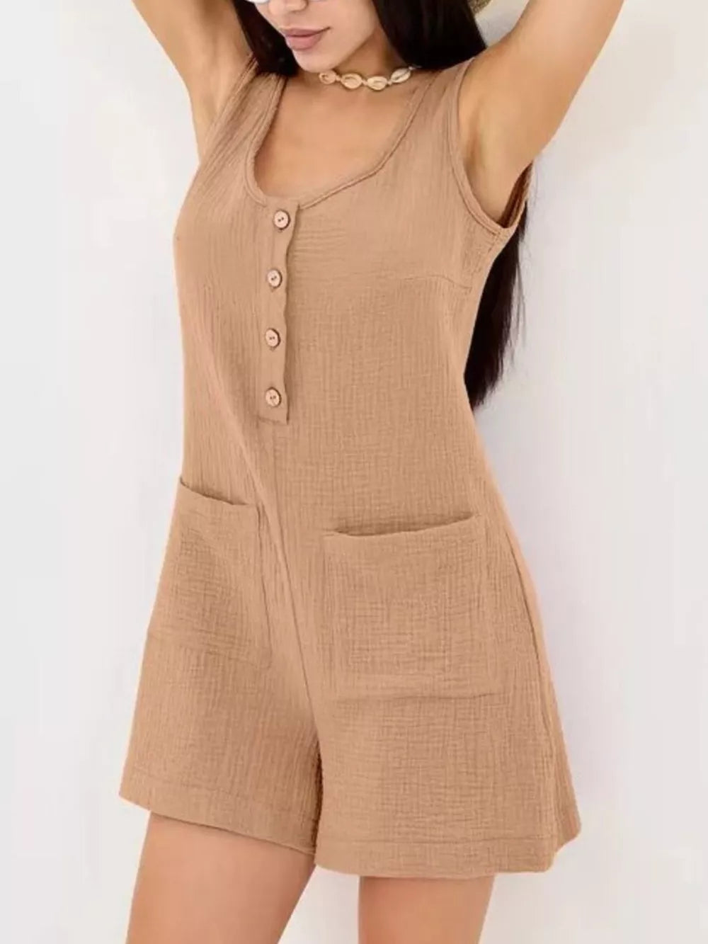 Khaki crinkled cotton button-down sleeveless romper with patch pockets.