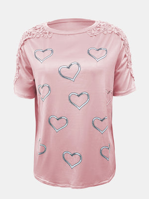 Blush pink tee with heart print and lace trim on shoulders and sleeves.