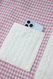 Panelled houndstooth shacket in dusty pink with quilted pocket detail and a phone.