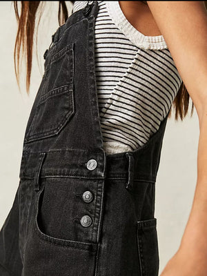 Black denim short overalls with button front and rolled hem detail.