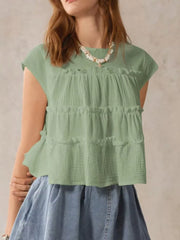 Green tiered ruffle blouse with short sleeves and textured fabric.