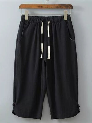 Black cropped sweatpants with drawstring and tie detail at hem.