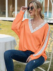 Orange waffle knit top with white lace trim V-neck and sleeve details.