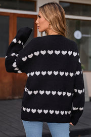 Black knit pullover sweater with white heart stripes, crew neck, long sleeves.