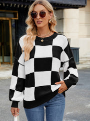 Checkerboard knit sweater in black and white with balloon sleeves and crew neck.