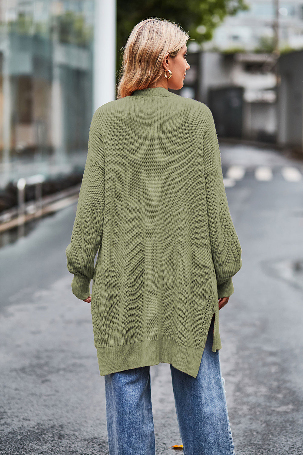 Sage open-knit longline cardigan with side slits and textured sleeves.