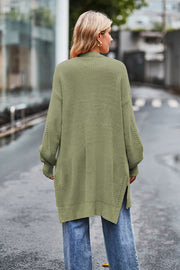 Sage open-knit longline cardigan with side slits and textured sleeves.