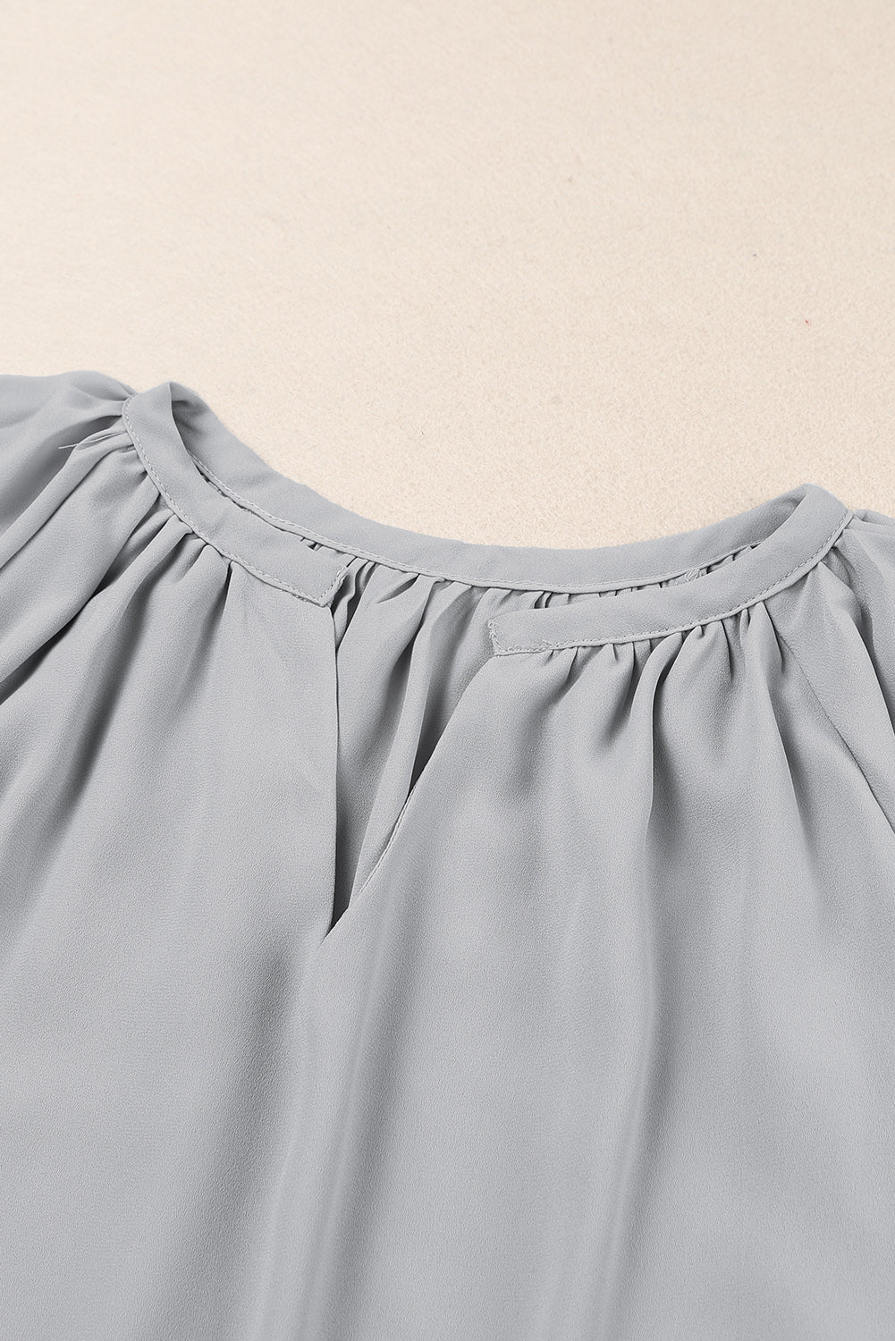 Gray relaxed V-neck blouse with gathered neckline and cap sleeves