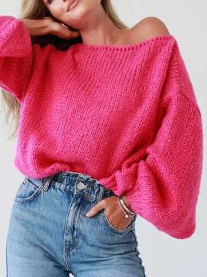 Hot pink chunky knit sweater with balloon sleeves and boat neck, styled with jeans.