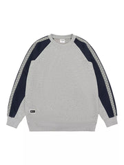 Oversized gray raglan sleeve sweatshirt with navy panels and zigzag trim detail.