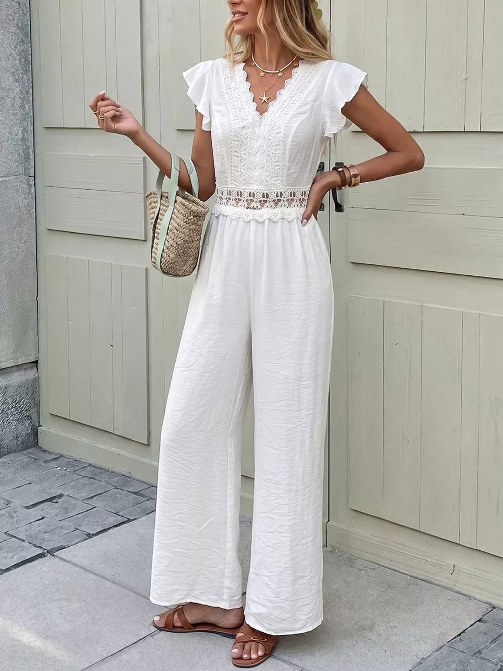 White lace-trimmed wide-leg romper with flutter sleeves and V-neck