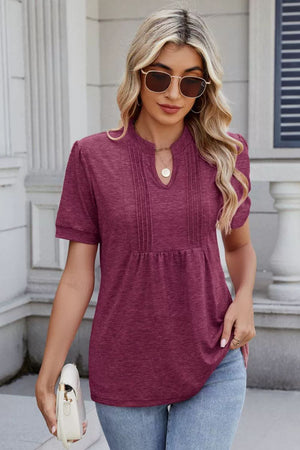 Plum purple short sleeve blouse with keyhole neckline and pleated yoke detail.