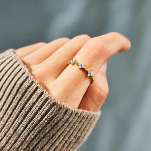 Gold band ring with celestial blossom details and small blue stones