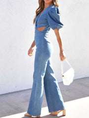 Light wash denim jumpsuit with puff sleeves, plunging neckline and cutout waist.