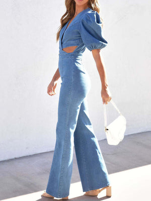 Light wash denim jumpsuit with puff sleeves, plunging neckline and cutout waist.