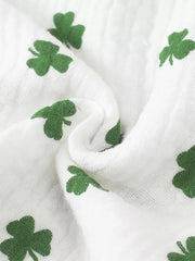 White cotton baby set with green shamrock print and ruffle detail.