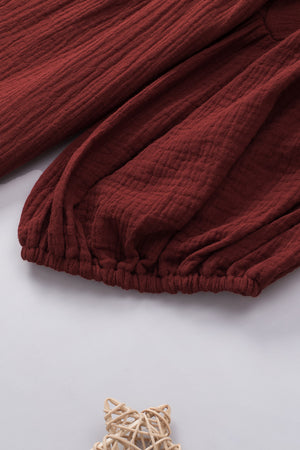 Textured gauze blouse in wine with gathered sleeves and elastic hem detail.