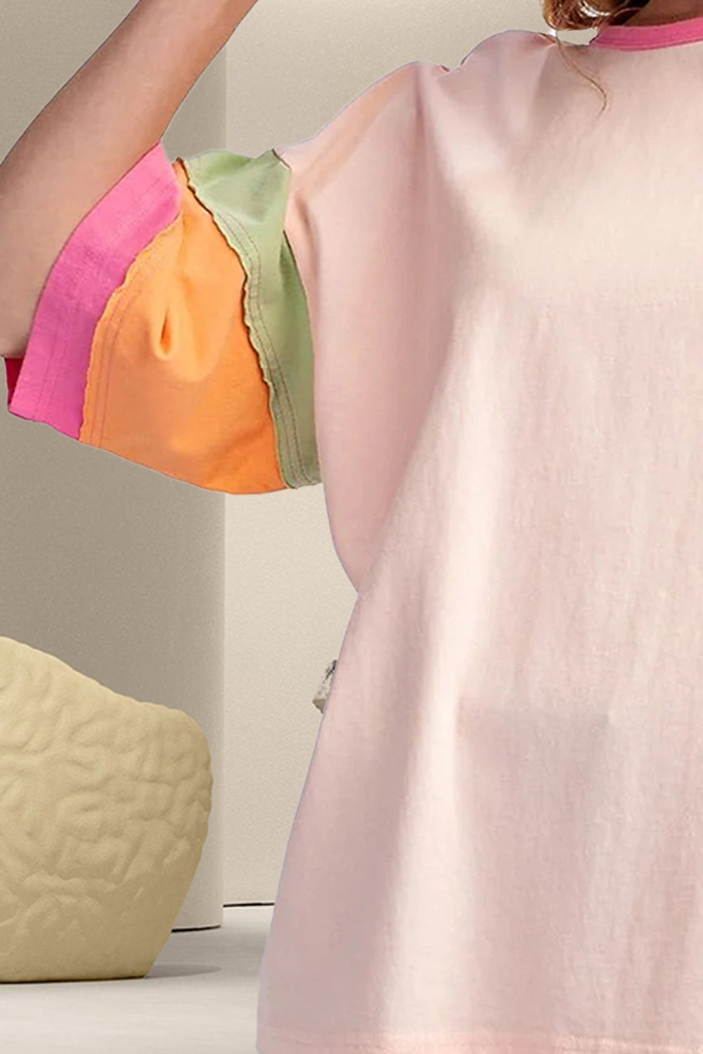 Blush pink t-shirt with colorblock rainbow raglan sleeves in pink, orange, and green.