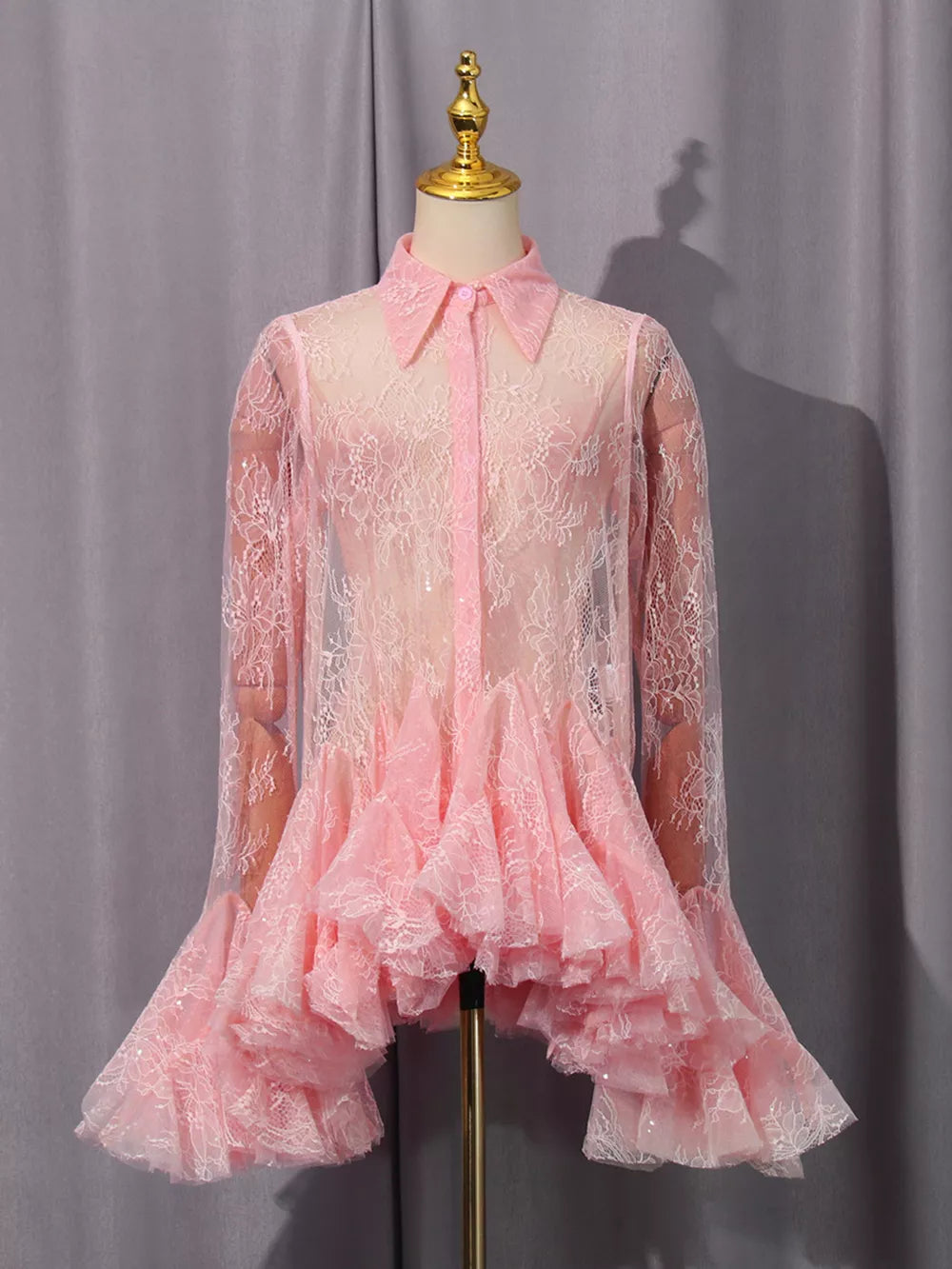 Pink floral lace dress with buttoned collar, long sleeves, and ruffled hem.