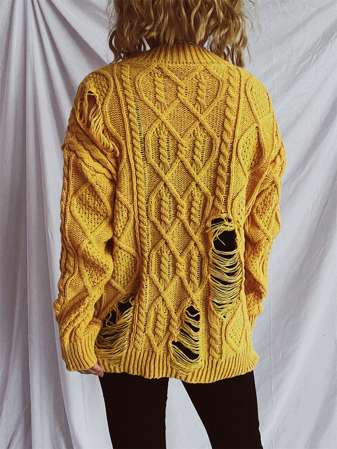 Mustard yellow distressed cable knit sweater with ripped details