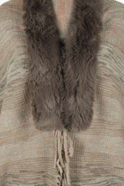 Textured knit cape in tan with faux fur collar and fringe detail