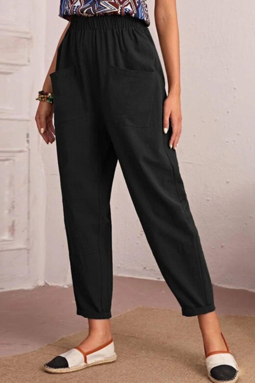 Black linen tapered trousers with elastic waist and pockets, cropped length