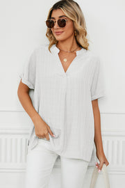 Blouse with rolled sleeves and V-neck in light grey with subtle vertical texture.