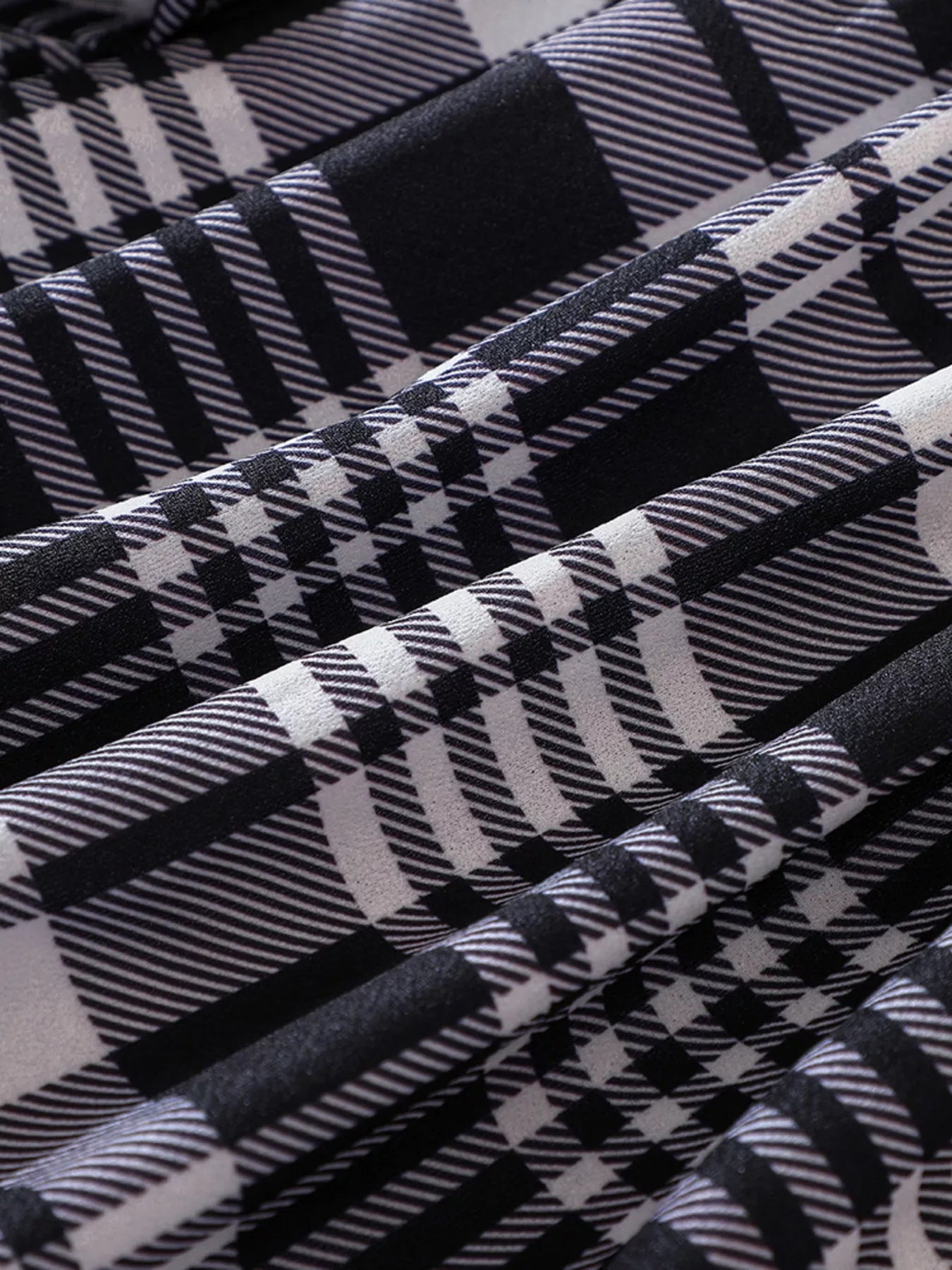 Belted plaid long-sleeve dress in black, close-up of fabric texture