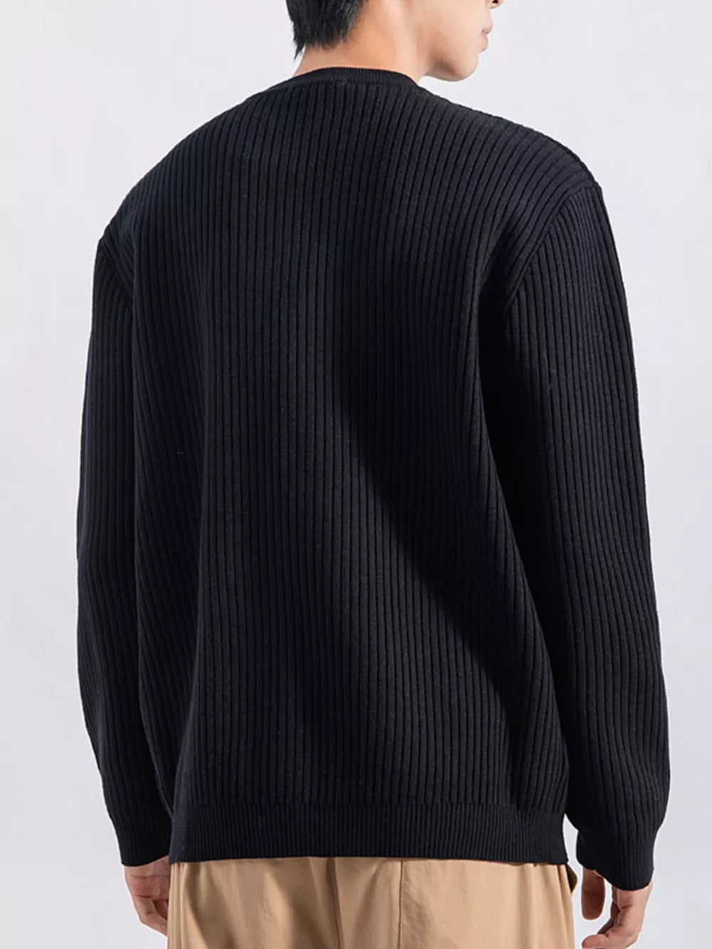 Men's black ribbed knit top with button details, crew neck, long sleeves.