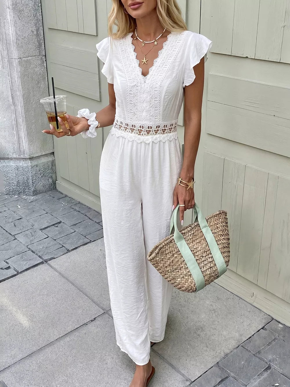 White lace-trimmed wide-leg romper with flutter sleeves and V-neck