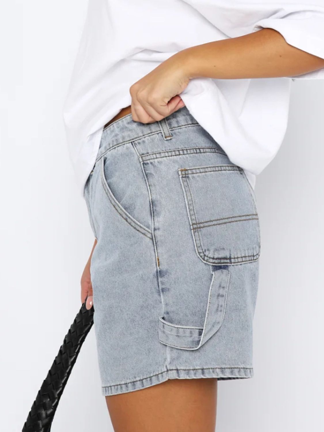 Light blue denim carpenter shorts with utility pockets and brass hardware detail.