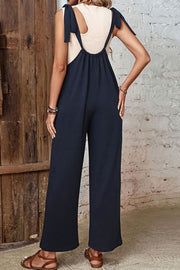 Dark blue suspender detail wide leg jumpsuit with tie shoulder straps.