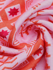 Pink halter neck midi dress fabric with orange geometric pattern and star details.