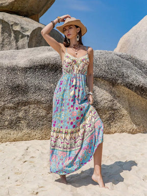 Maxi dress with floral border print, tassel detail, and spaghetti straps.