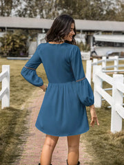 Blue V-neck balloon sleeve dress with decorative trim on sleeves and cinched waist.
