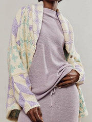 Geometric patchwork knit cardigan in cream with purple and green diamond pattern.