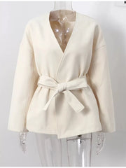 Chic beige surplice trench coat with tie waist and dropped shoulders.